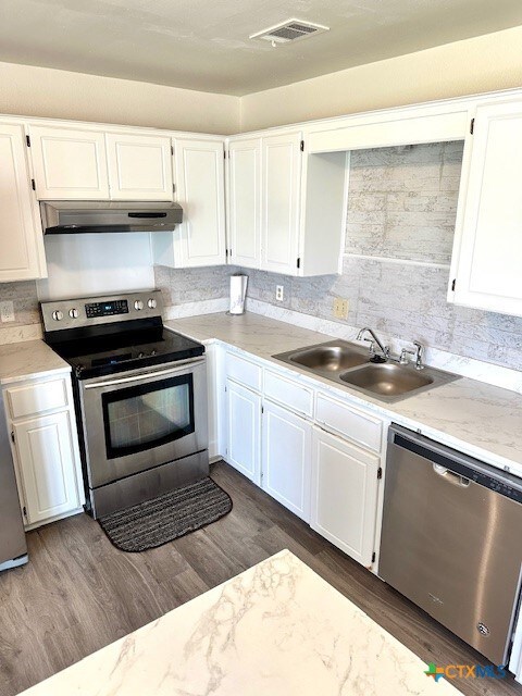 4505 Mustang Dr, Killeen, TX 76549 - kitchen with under cabinet range hood, stainless steel appliances, white cabinetry, and a sink