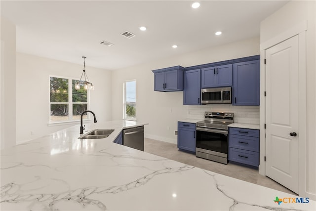 kitchen with light stone counters, stainless steel appliances, a sink, visible vents, and backsplash