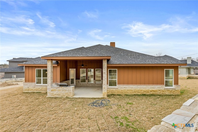 back of property featuring ceiling fan, a patio, a yard, and stone siding