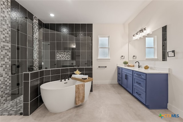 bathroom featuring vanity, baseboards, tile walls, a soaking tub, and a tile shower