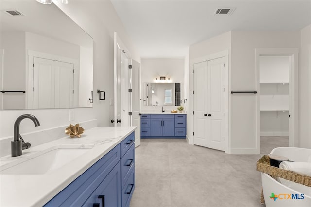 full bathroom with a closet, two vanities, a sink, and visible vents