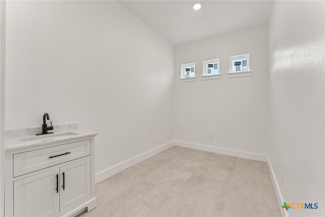 interior space with recessed lighting, a sink, and baseboards