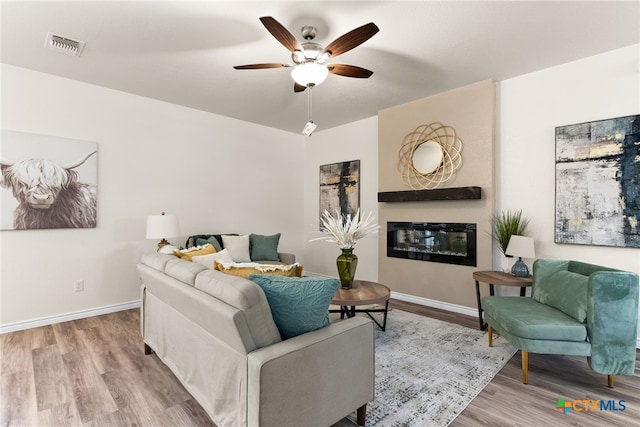 5002 Rose Garden Loop, Killeen, TX 76542 - living room featuring visible vents, a glass covered fireplace, wood finished floors, baseboards, and ceiling fan