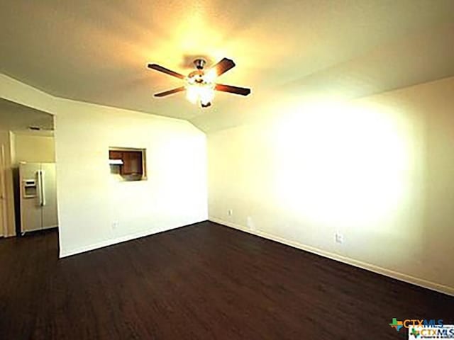 empty room with ceiling fan, dark wood-type flooring, and vaulted ceiling