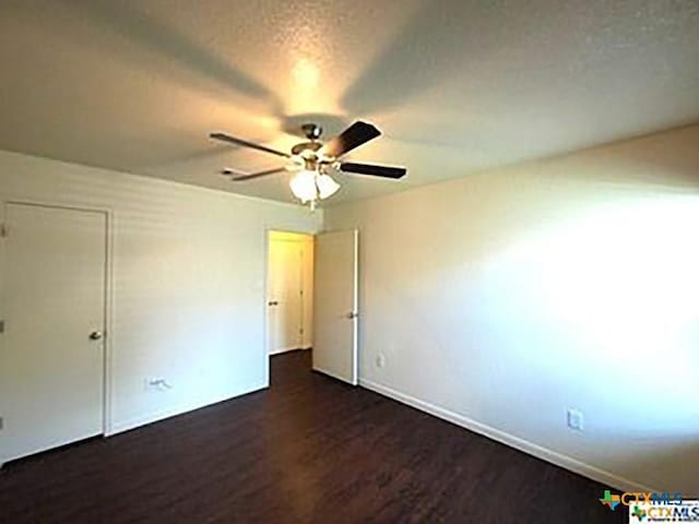 unfurnished bedroom featuring a textured ceiling, ceiling fan, and dark hardwood / wood-style floors