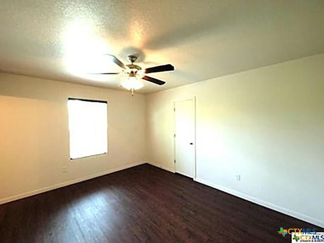 unfurnished room with dark wood-type flooring and a textured ceiling