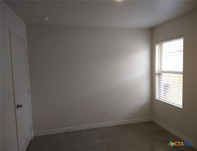 unfurnished room with baseboards