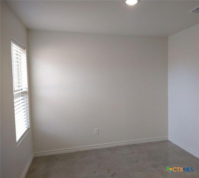 unfurnished room with visible vents and baseboards