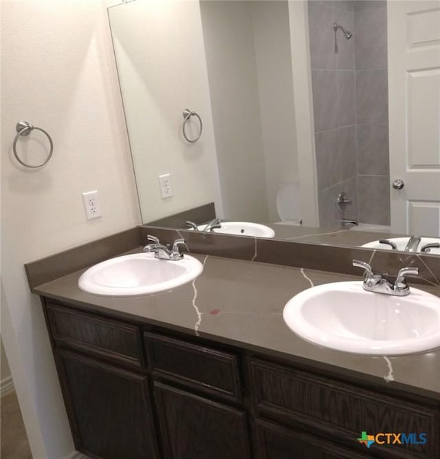 full bath featuring a sink, toilet, and double vanity