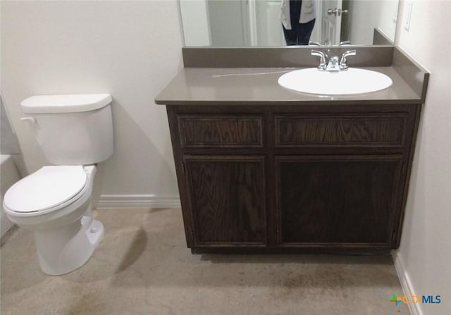 bathroom featuring baseboards, toilet, and vanity