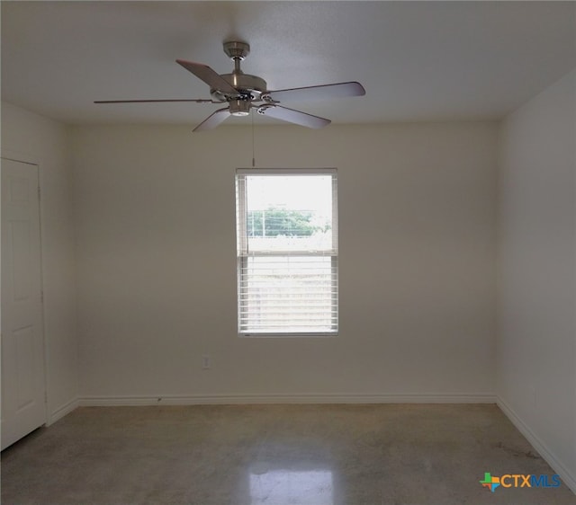 spare room featuring a ceiling fan and baseboards