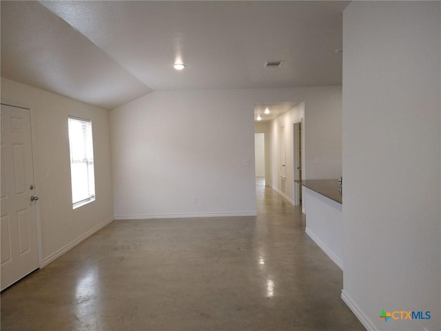 foyer featuring baseboards, visible vents, lofted ceiling, and concrete floors