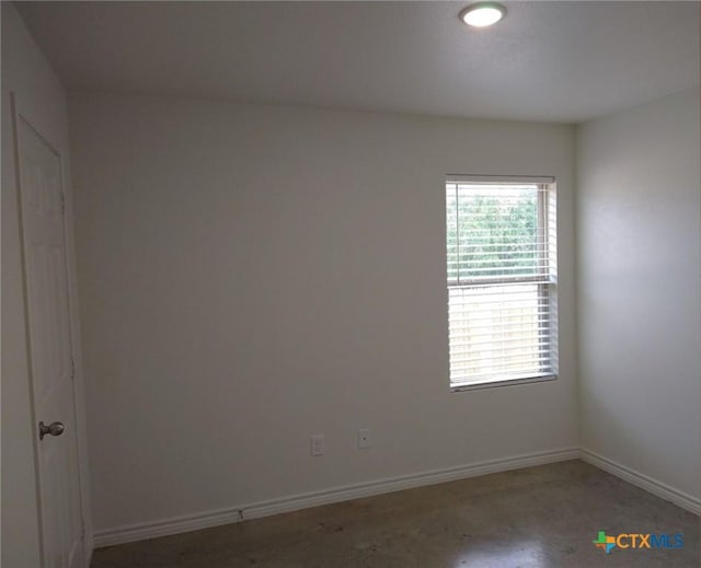 unfurnished room with baseboards