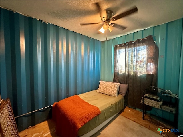 bedroom featuring ceiling fan, a textured ceiling, and carpet floors