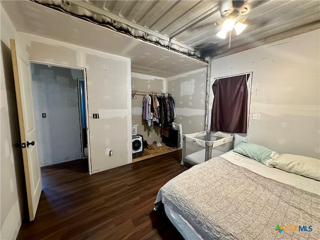 bedroom with dark wood-type flooring, ceiling fan, and a closet