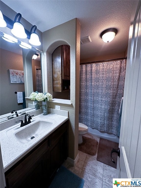 bathroom with vanity, a textured ceiling, and toilet