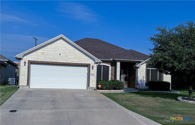 view of front of house with central air condition unit, a front lawn, and a garage