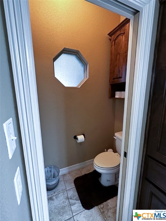 bathroom featuring toilet and tile patterned flooring