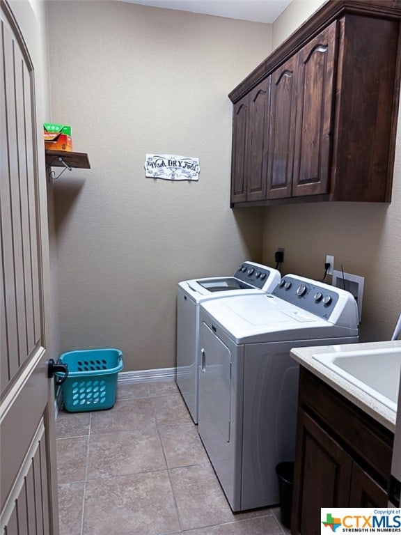 laundry room with cabinets, independent washer and dryer, and light tile patterned floors