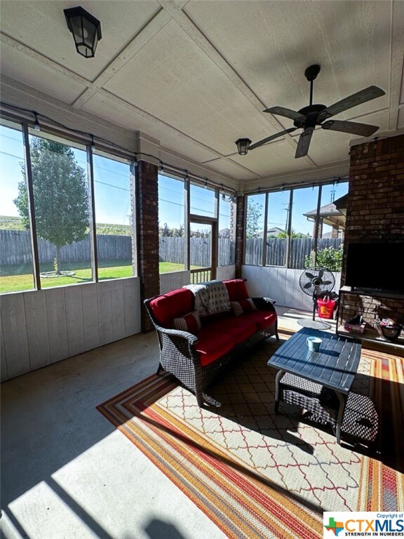 sunroom with a healthy amount of sunlight and ceiling fan