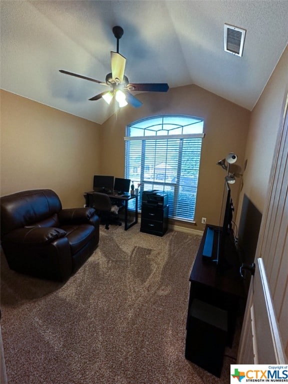 carpeted living room with ceiling fan and vaulted ceiling