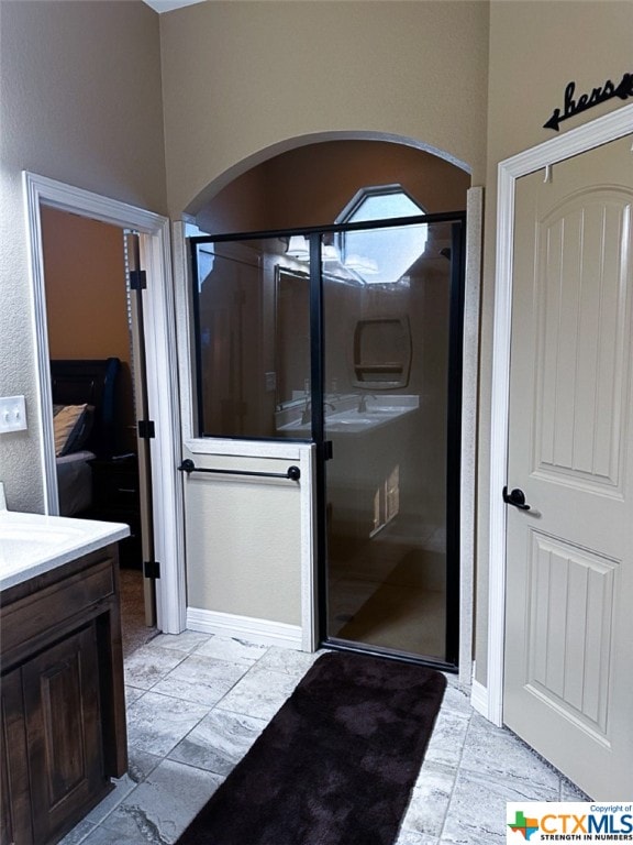 bathroom featuring vanity and a shower with door