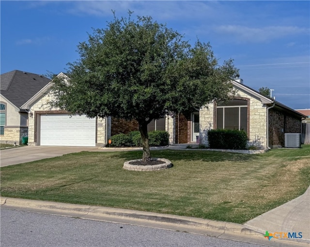 view of front of house featuring a garage, cooling unit, and a front lawn