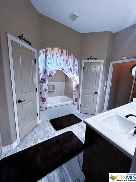 bathroom featuring a bath and vanity