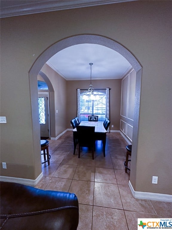 dining area featuring an inviting chandelier, tile patterned floors, and ornamental molding