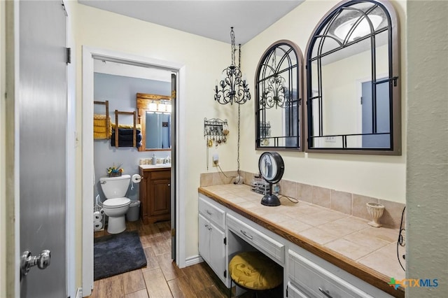 bathroom featuring toilet, vanity, and wood finish floors