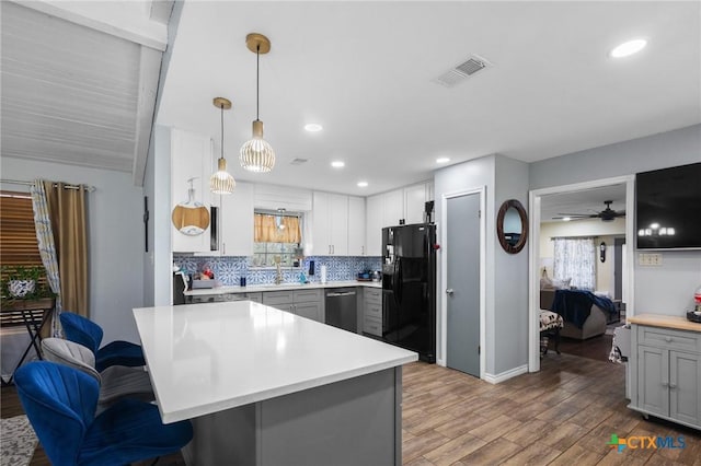 kitchen with visible vents, dishwasher, gray cabinets, and black fridge