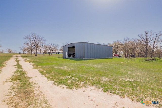view of pole building featuring a lawn and driveway