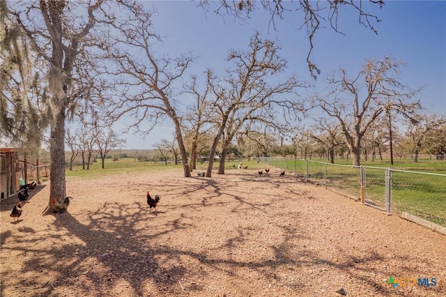 view of yard with a rural view, fence, and a gate