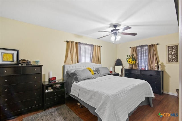 bedroom with dark wood-style floors, baseboards, and ceiling fan