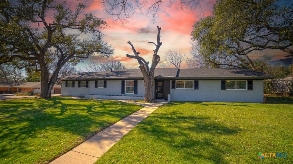 single story home featuring a front lawn