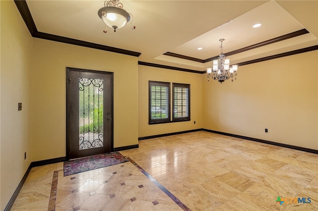 foyer entrance featuring ornamental molding, a notable chandelier, and a tray ceiling