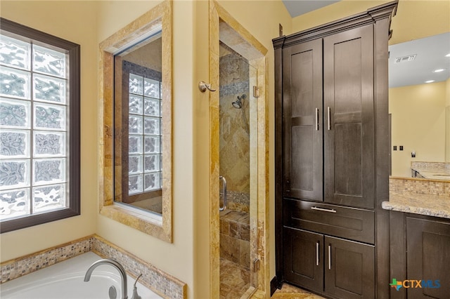 bathroom with vanity and separate shower and tub