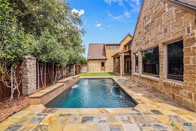 view of pool with a patio and pool water feature