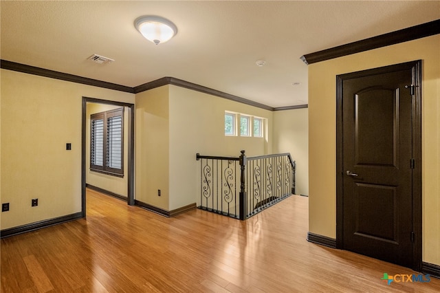 hallway featuring light hardwood / wood-style floors and ornamental molding