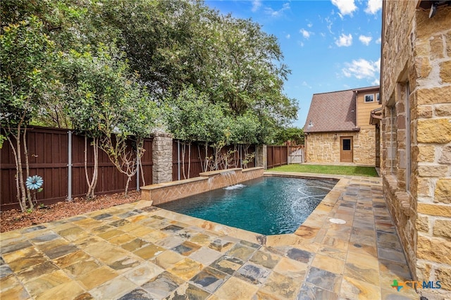 view of pool featuring pool water feature and a patio area