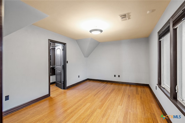 additional living space featuring light hardwood / wood-style flooring and vaulted ceiling