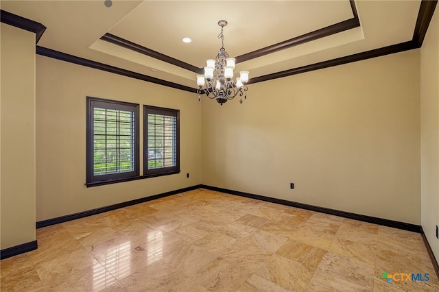 empty room with a tray ceiling, an inviting chandelier, and ornamental molding