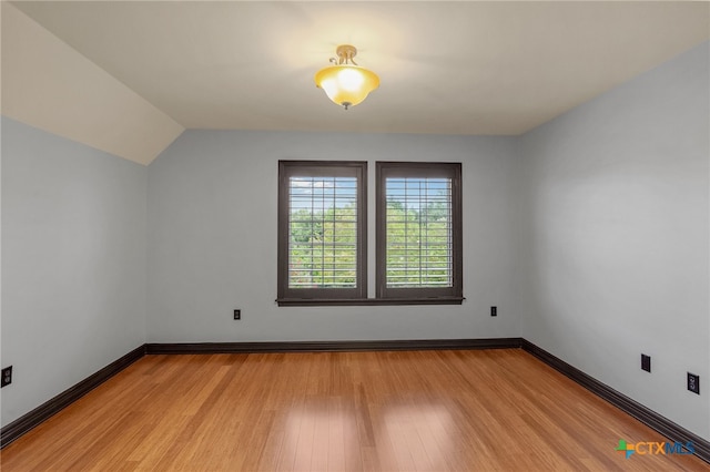 additional living space featuring vaulted ceiling and light hardwood / wood-style flooring