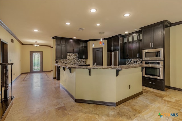 kitchen with backsplash, an island with sink, ornamental molding, and stainless steel appliances