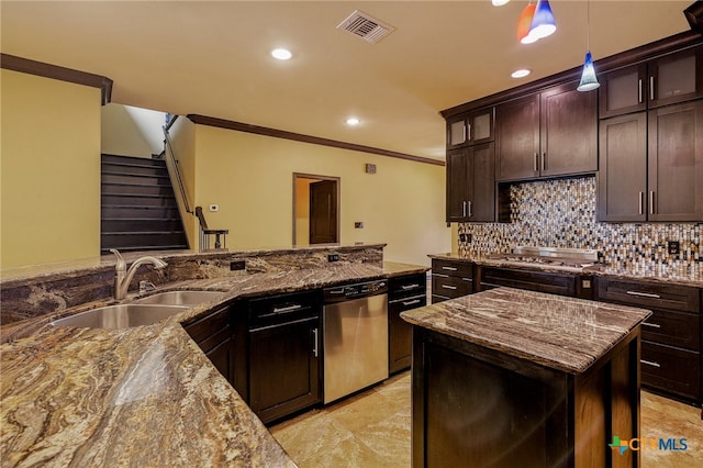 kitchen featuring stone countertops, sink, appliances with stainless steel finishes, a kitchen island, and pendant lighting