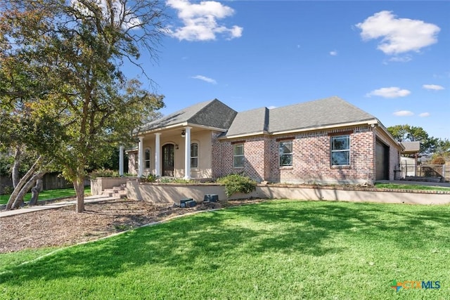 view of front of home with covered porch, a garage, and a front yard