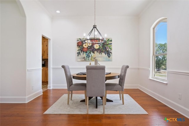 dining space featuring a chandelier, dark hardwood / wood-style floors, and crown molding