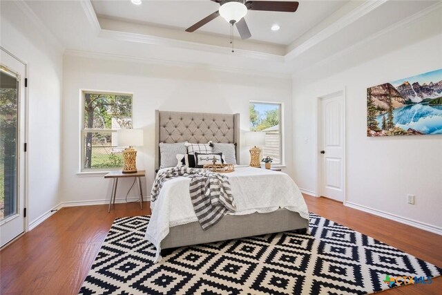 bedroom featuring access to exterior, hardwood / wood-style flooring, a raised ceiling, and ceiling fan