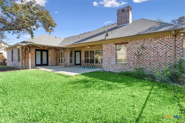 back of house featuring a patio area and a lawn