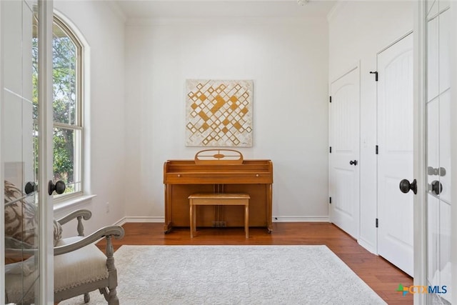 sitting room with french doors, crown molding, and hardwood / wood-style floors